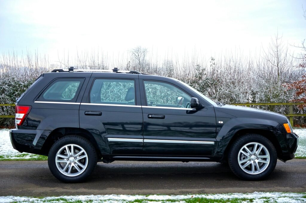 A black SUV parked outdoors on a snowy road surrounded by a winter landscape.