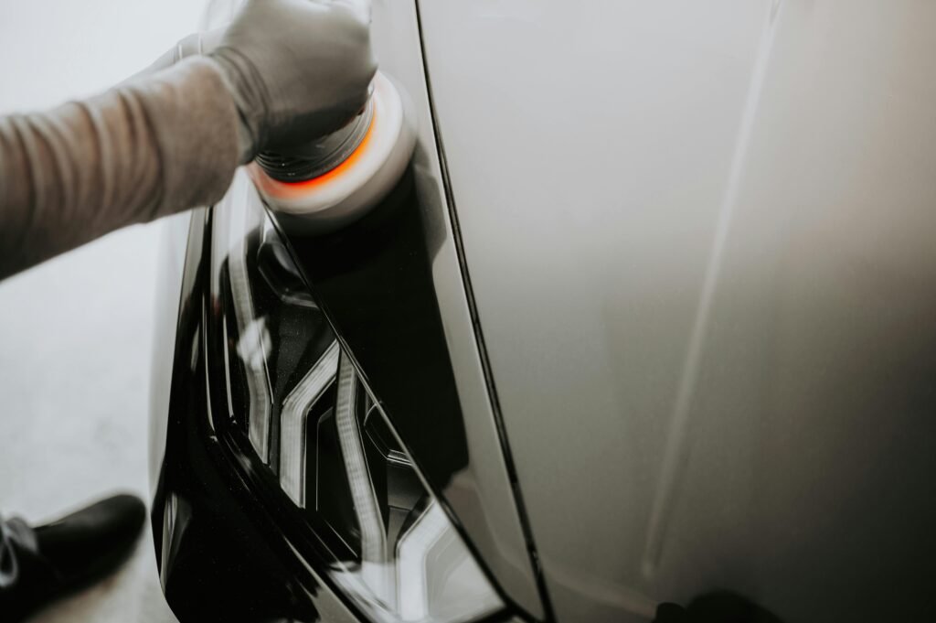pexels-photo-14231684-14231684 Close-up view of a person polishing a black car using a buffing machine.
