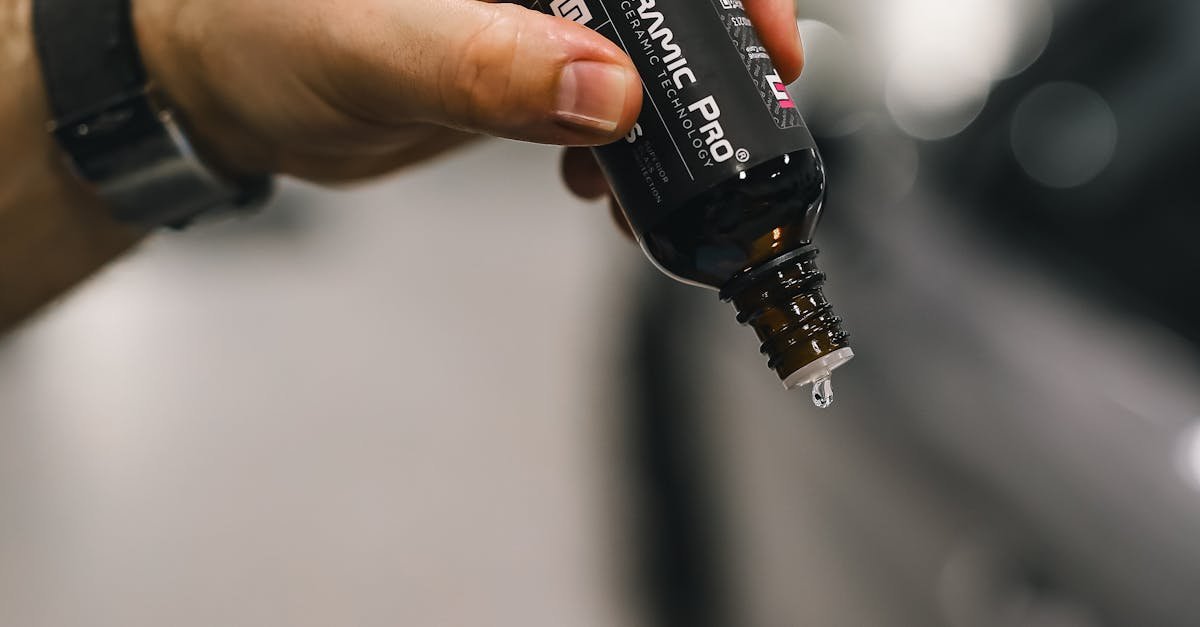 pexels-photo-20051453-20051453 Close-up of hands applying ceramic coating on car with blue sponge.