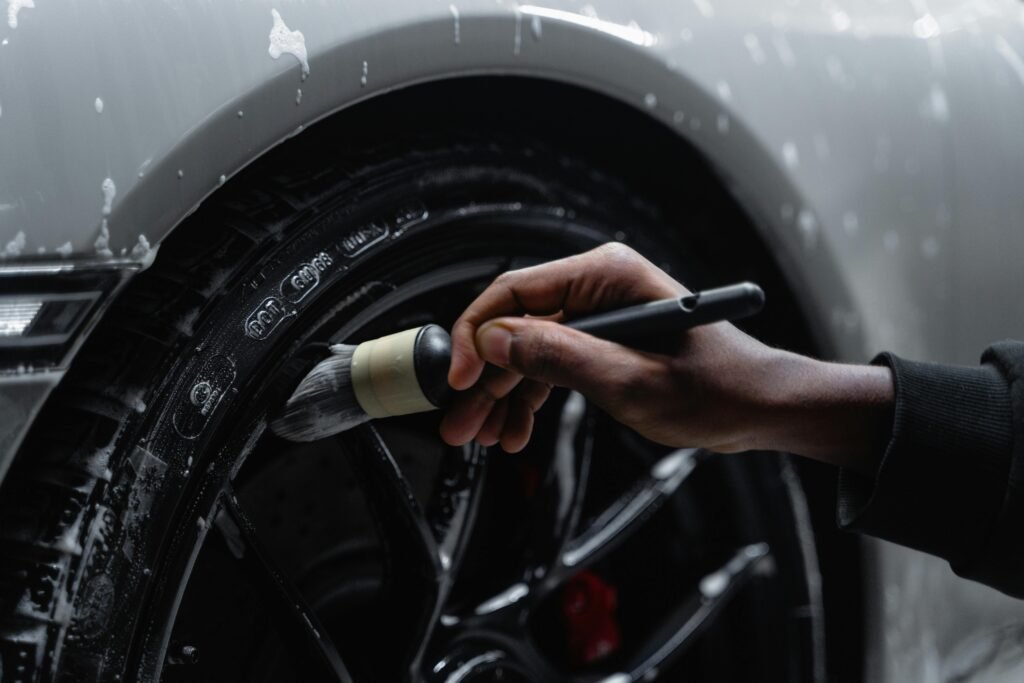 pexels-photo-6872147-6872147 Detailed shot of a hand using a brush to clean a car tire and wheel during a wash. Premier Auto Detailing & Ceramic Coating | Ocean View NJ
