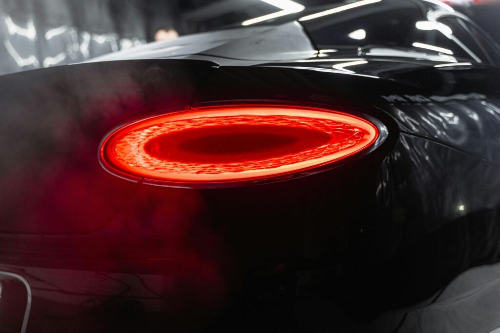 pexels-photo-6872573-6872573 Close-up view highlighting the sleek design of a luxury black car's illuminated tail light.