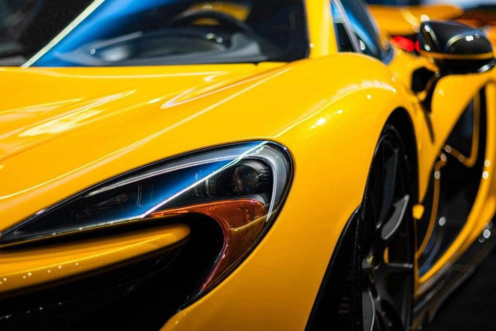 pexels-photo-30849335-30849335 Close-up shot of a sleek yellow luxury sports car headlight, showcasing elegance and design.